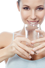 Smiling woman drinking water.